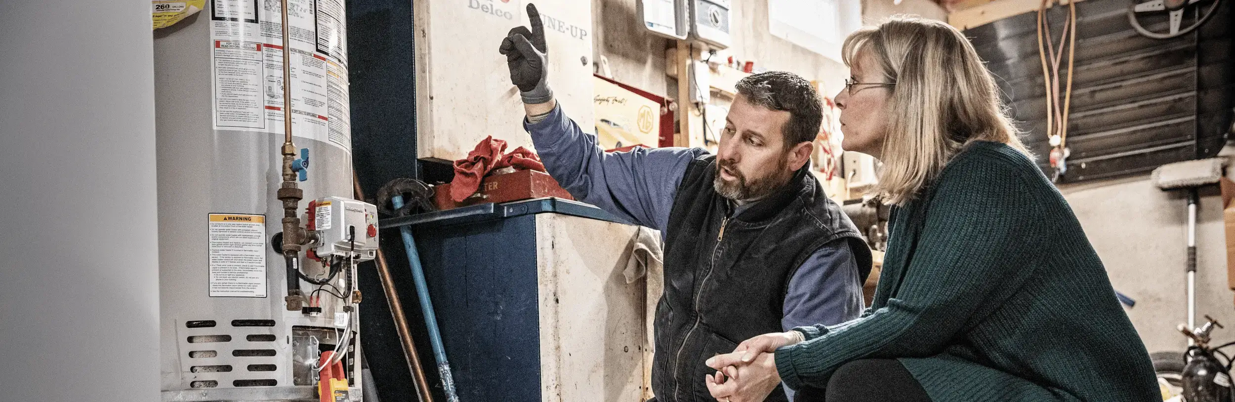 Worker showing lady water heater problems