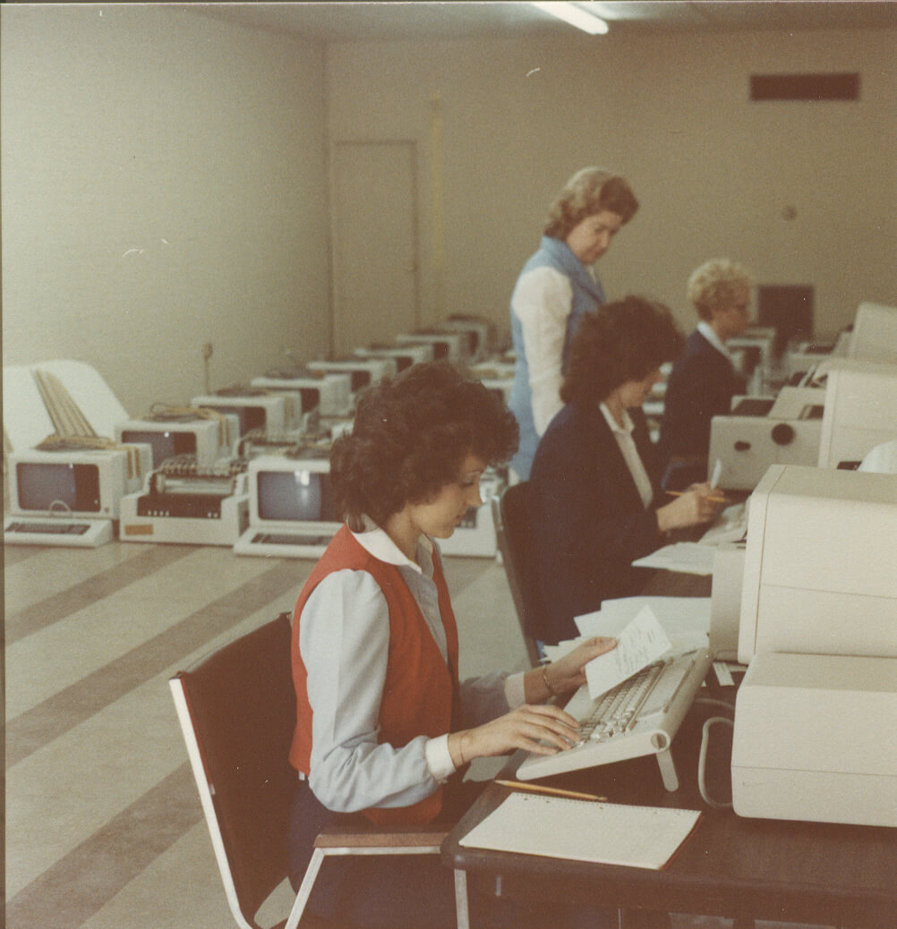 Blossman employees working on old computers